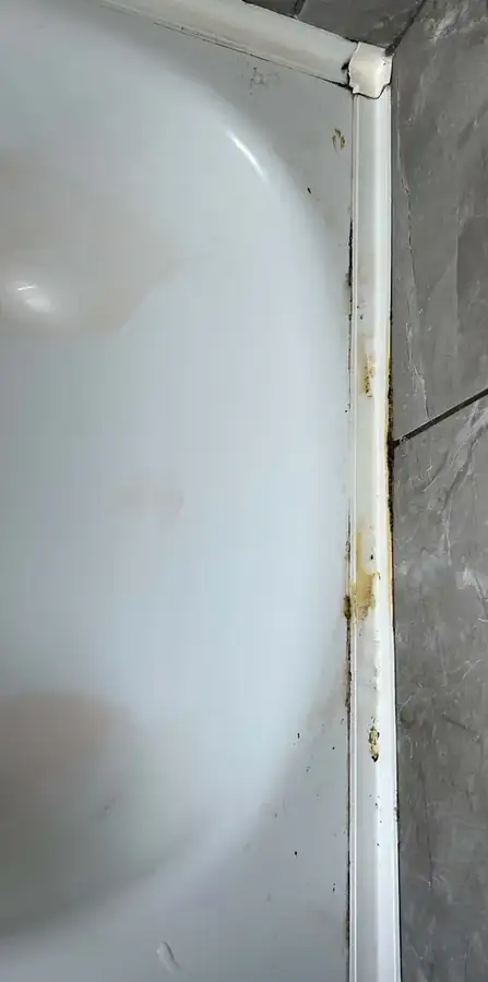 Bath edge and sealant before cleaning